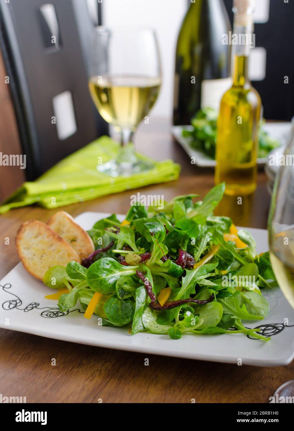 Salade de roquette, laitue d'agneau, poivrons et oignons caramélisés. L'huile d'olive croustillant de boulangerie baguettes Banque D'Images