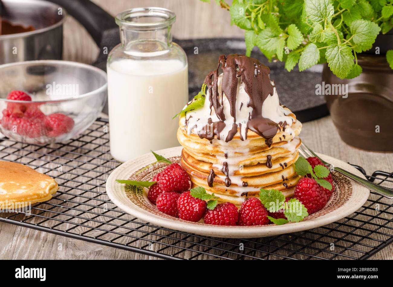 Crêpes américaines avec glace et chocolat, herbes et baies autour Banque D'Images