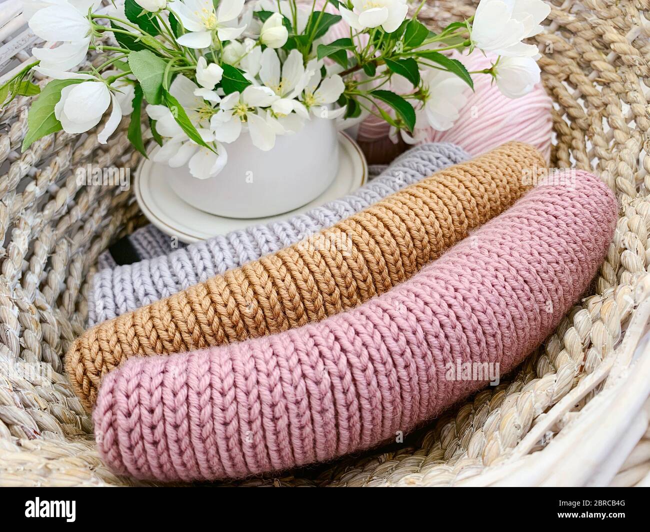 tricoté, éléments colorés et fleur de pommier dans le panier Banque D'Images