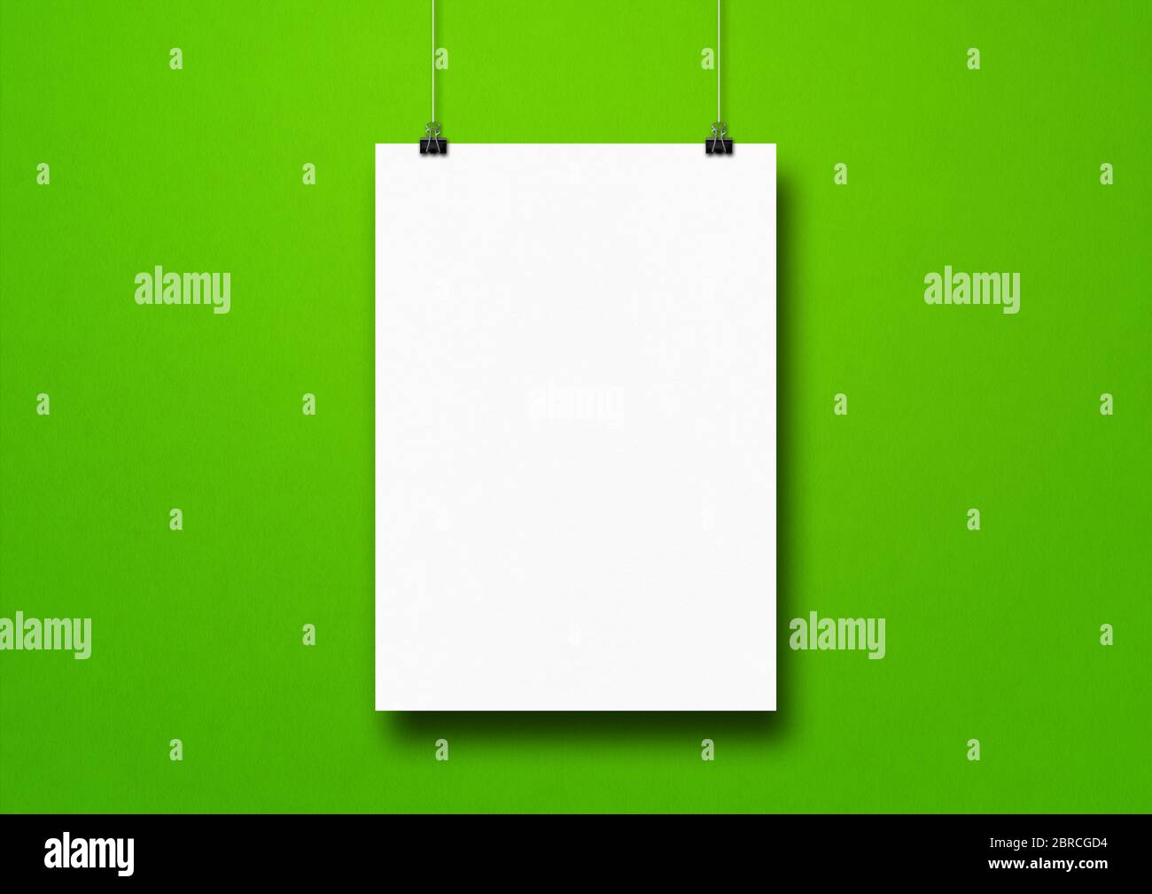 Affiche blanche suspendue sur un mur vert avec des pinces. Modèle de maquette vide Banque D'Images
