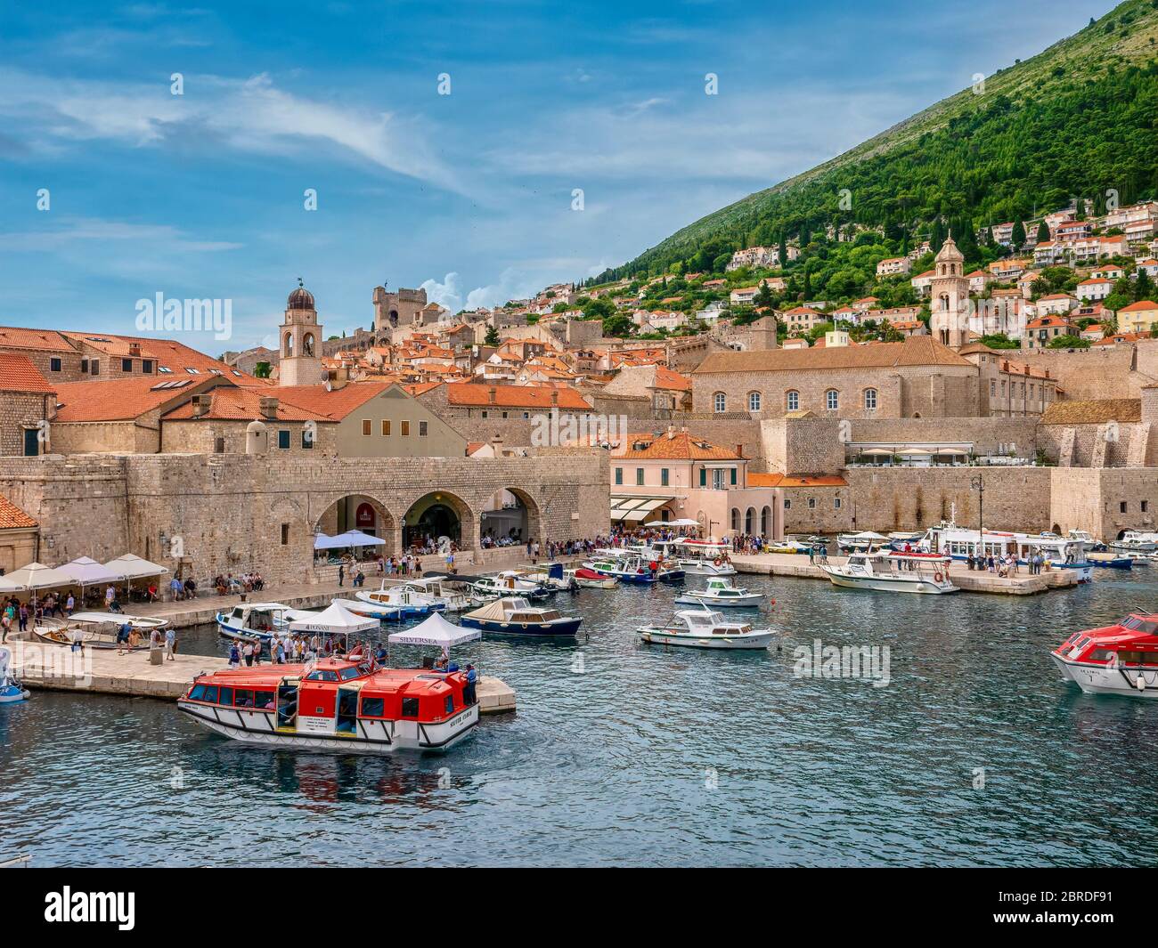 Dubrovnik, Croatie - 3 juin 2016. Vue panoramique sur le front de mer de la vieille ville de Dubrovnik, avec ses touristes, ses bateaux amarrés et ses navettes de croisière. Banque D'Images