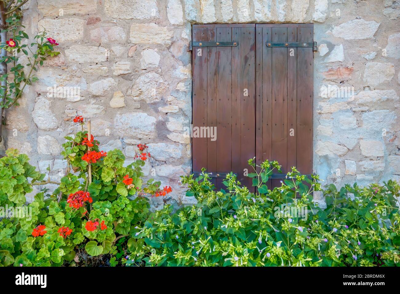 Volets en bois fermés sur le mur en pierre d'une ancienne ferme française dans un village rural de Provence, France. Banque D'Images