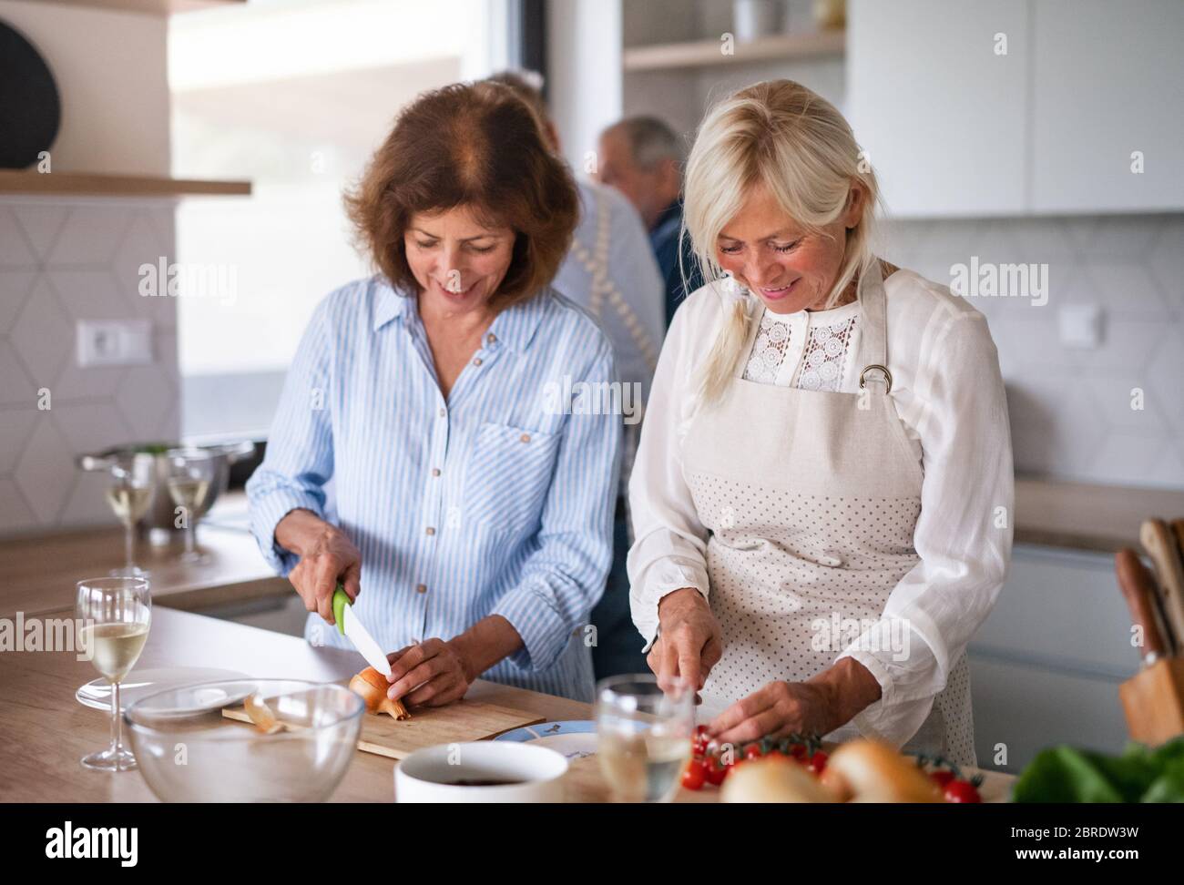 Groupe d'amis senior à dîner à la maison, cuisine. Banque D'Images