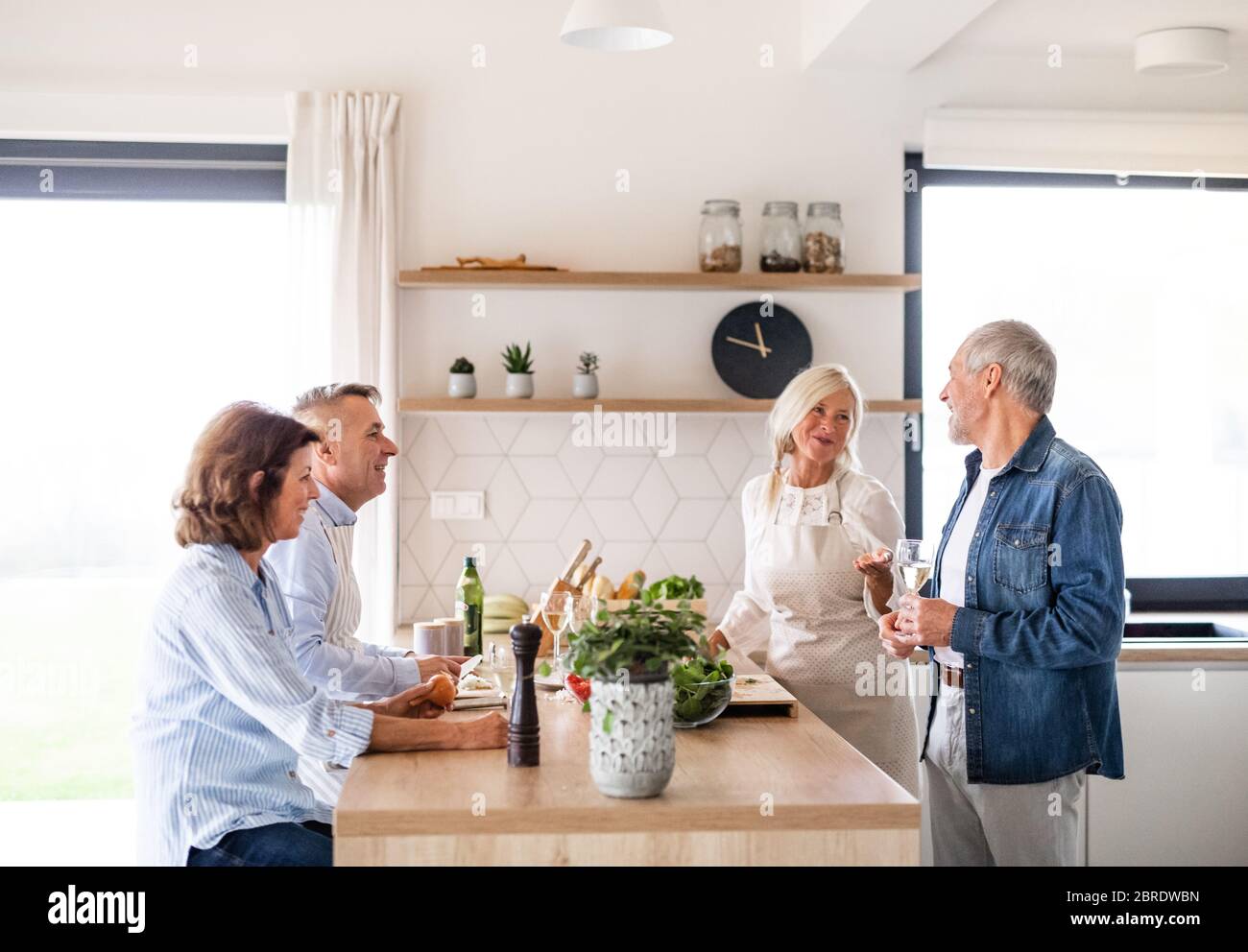 Groupe d'amis senior à dîner à la maison, cuisine. Banque D'Images