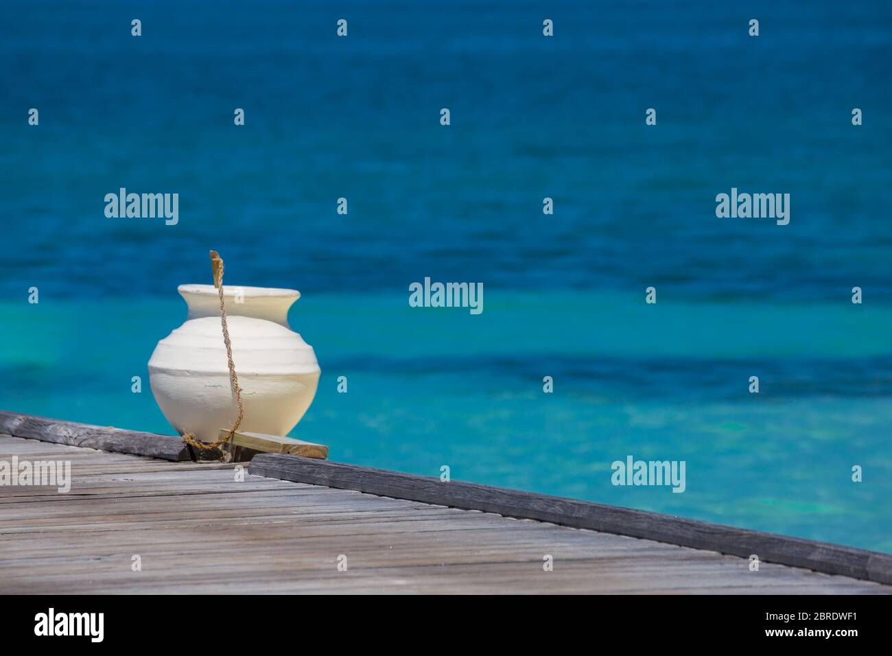 Jetée en bois vers une petite île sur l'Océan Indien, les Maldives. Ciel bleu ensoleillé. Banque D'Images