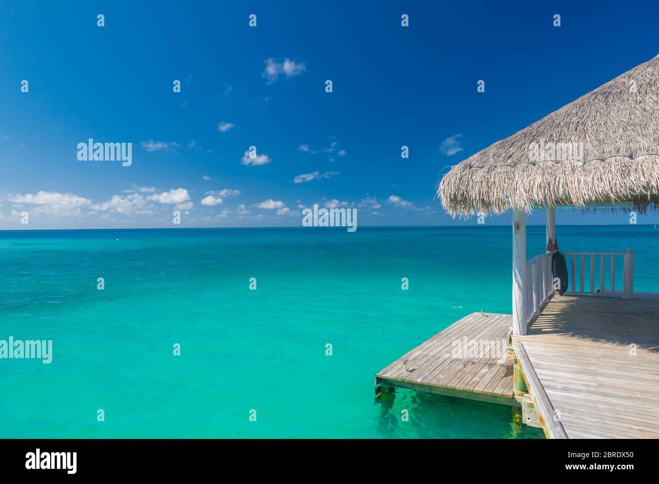 Magnifique coucher de soleil tropical avec villas en bois sur l'eau de l'océan Indien, île des Maldives. Spa luxueux sur l'eau, mer tropicale bleue Banque D'Images