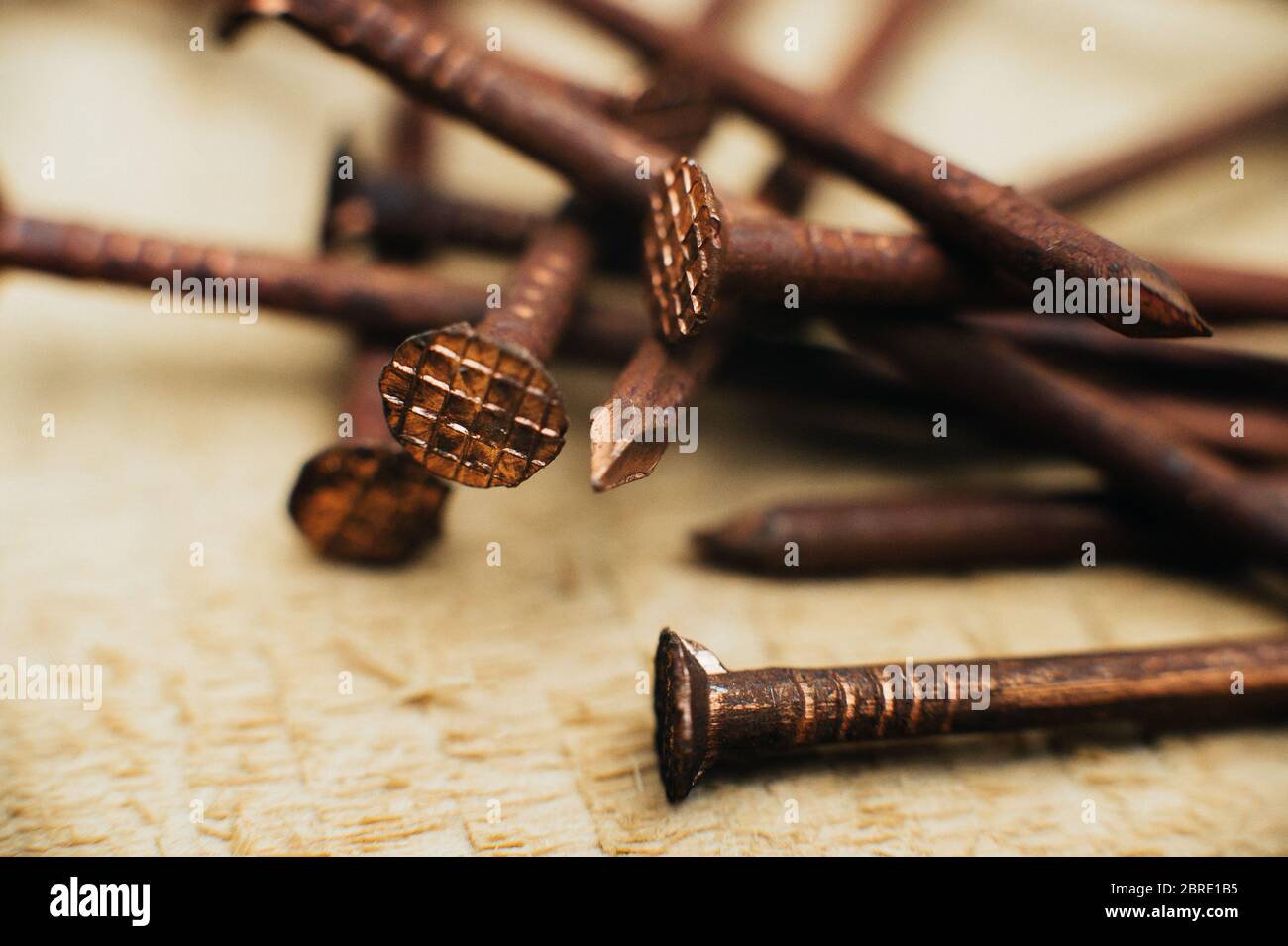 Ferraille cuivre, vieux cuivre sale ongles oxydés. Sur fond de bois non traité. Gros plan. Macro. Banque D'Images