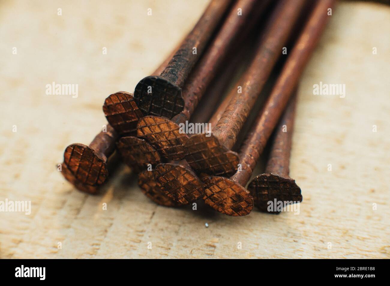 Ferraille cuivre, vieux cuivre sale ongles oxydés. Sur fond de bois non traité. Gros plan. Macro. Banque D'Images