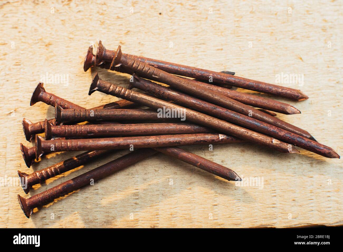 Ferraille cuivre, vieux cuivre sale ongles oxydés. Sur fond de bois non traité. Gros plan. Macro. Banque D'Images