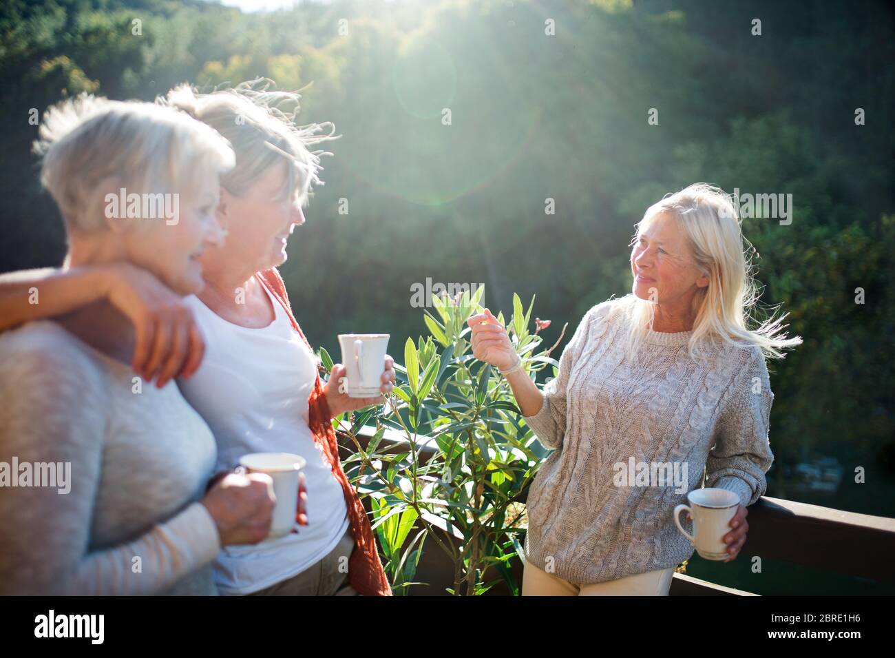 Des femmes âgées, des amis debout à l'extérieur sur la terrasse, parlant. Banque D'Images