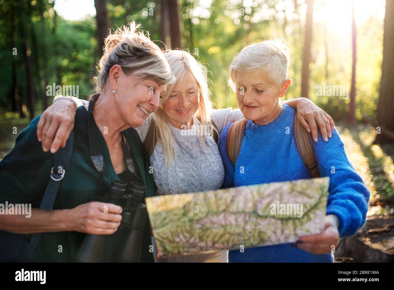 Les femmes âgées s'amis à l'extérieur dans la forêt, en utilisant la carte et des jumelles. Banque D'Images