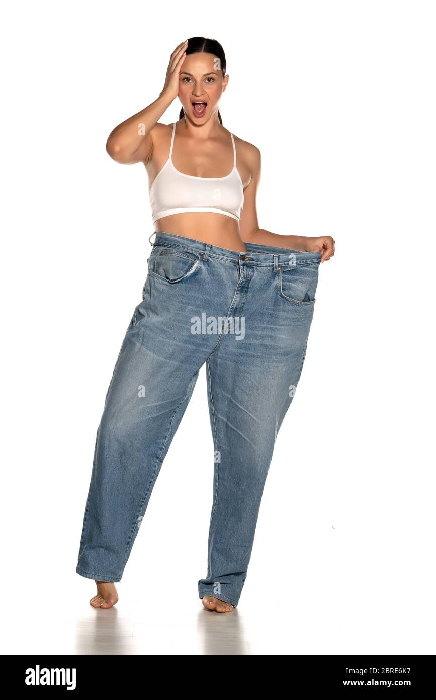 Jeune femme mince dans un pantalon de grande taille sur fond blanc Photo  Stock - Alamy