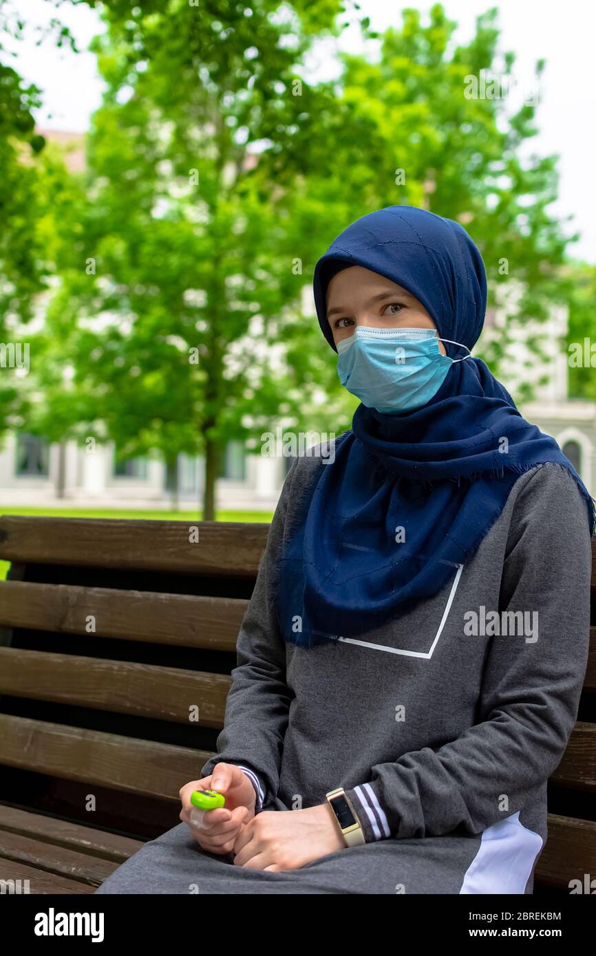 Femme musulmane européenne moderne portant un masque chirurgical priant le  testicule numérique dans le parc Photo Stock - Alamy