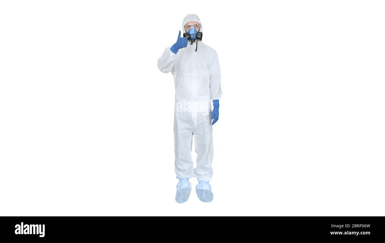 Homme en costume de protection, un masque et un respirateur Thumb vers le haut sur fond blanc. Banque D'Images