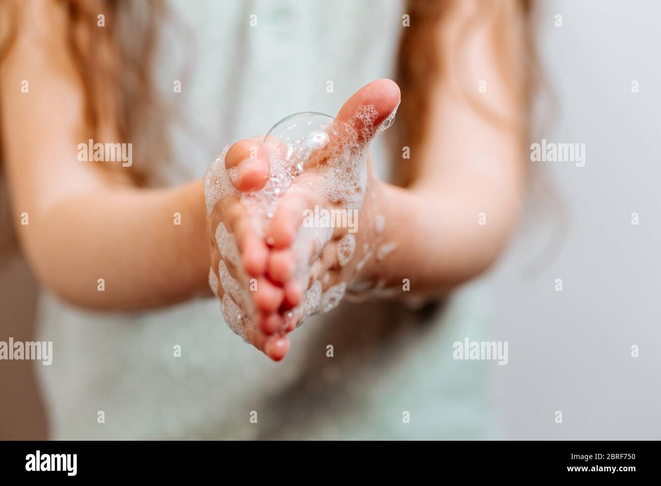 Mains pour enfants en mousse savonneuse. N'oubliez pas de se laver les mains Banque D'Images