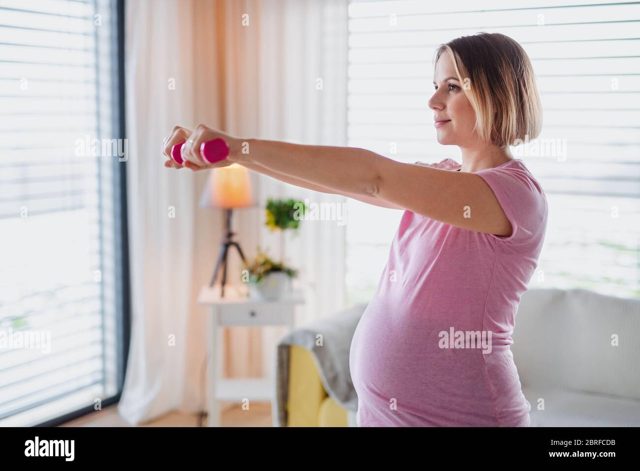 Portrait de la femme enceinte à l'intérieur à la maison, faisant de l'exercice. Banque D'Images