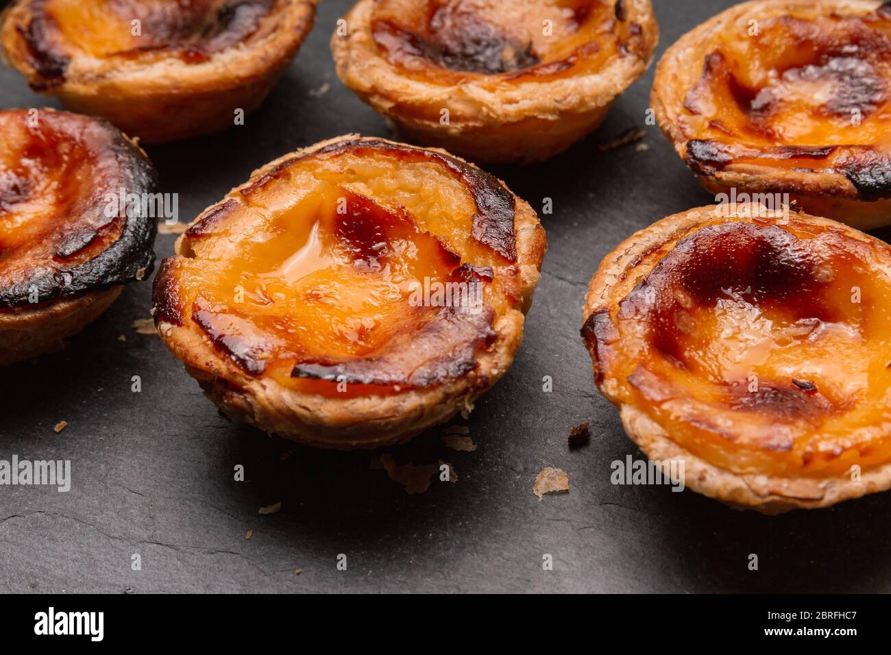gros plan sur le portugais 'pasteis de nata', tarte à la crème anglaise sur fond sombre Banque D'Images