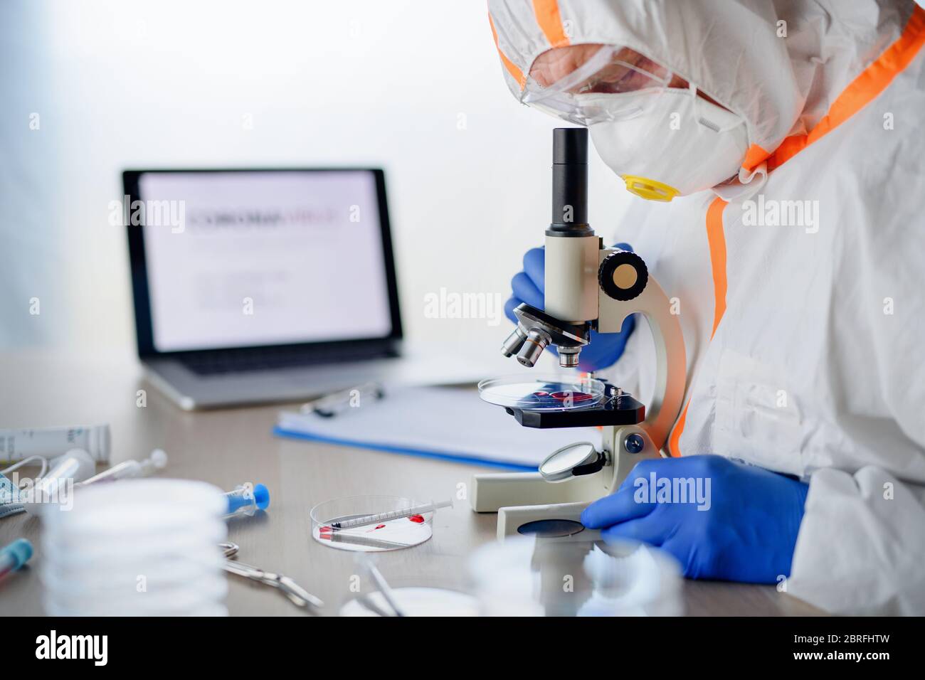 Médecin avec microscope analysant des échantillons de sang, concept de coronavirus. Banque D'Images