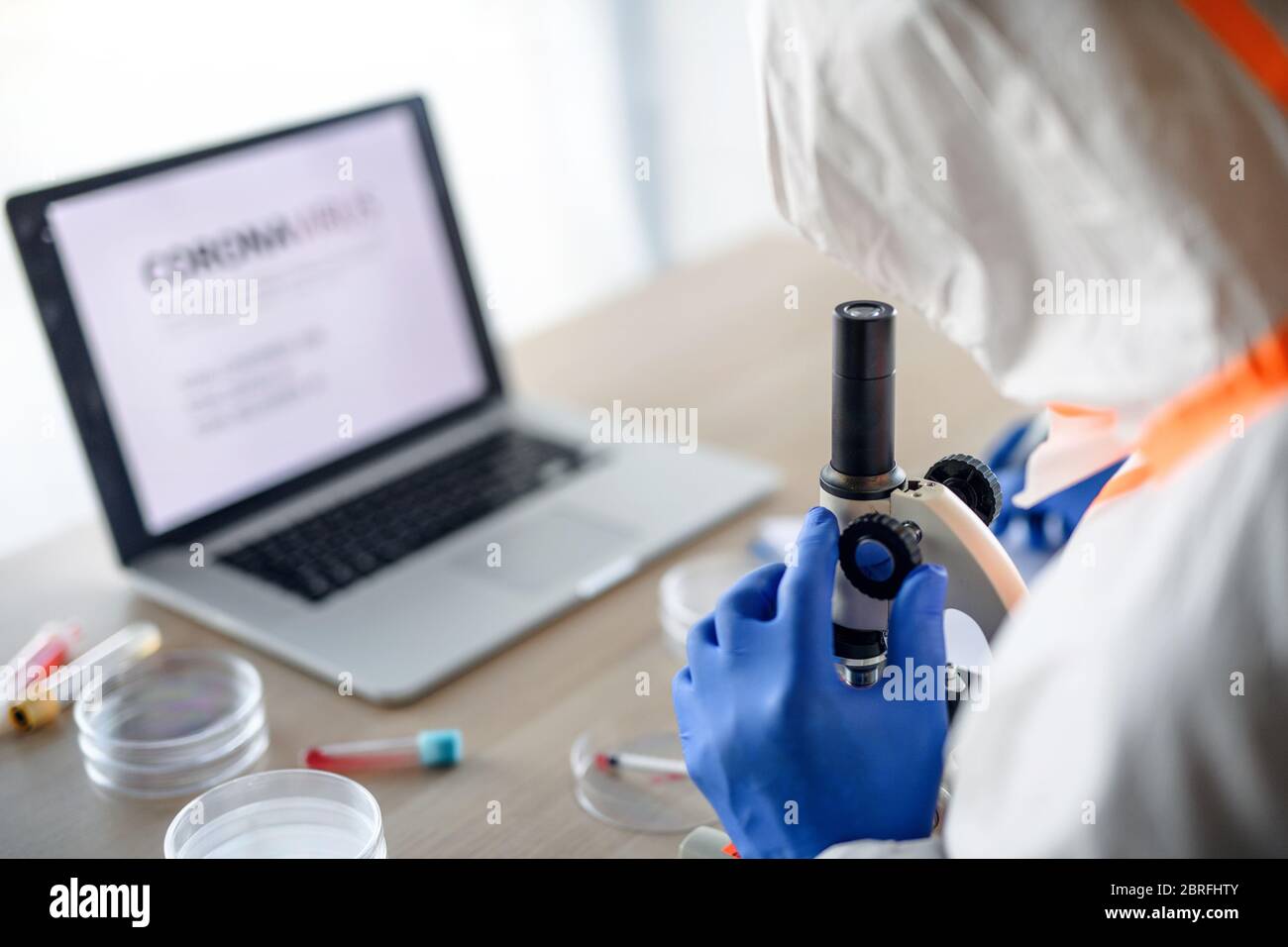 Médecin avec microscope analysant des échantillons de sang, concept de coronavirus. Banque D'Images
