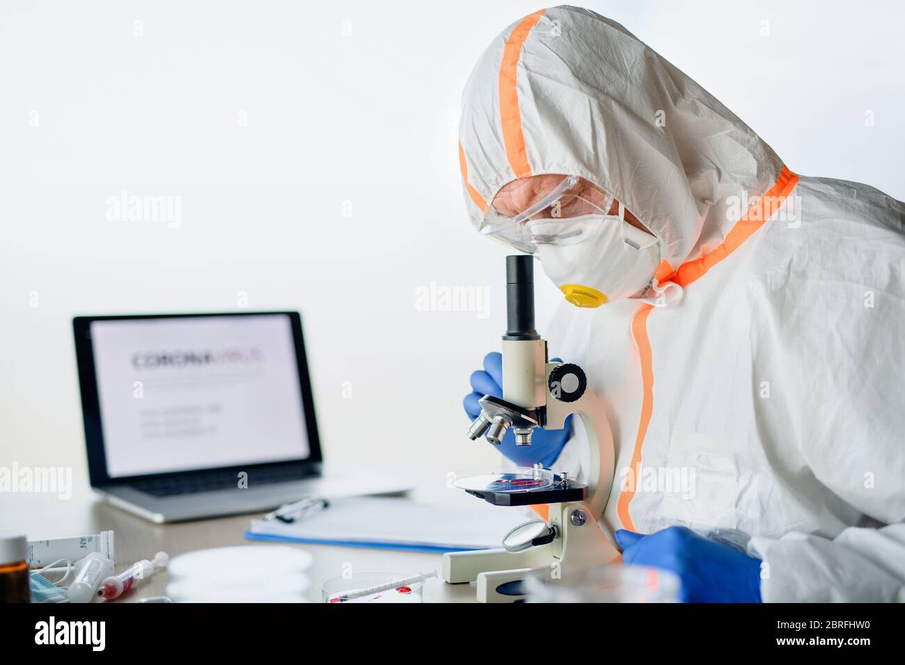 Médecin avec microscope analysant des échantillons de sang, concept de coronavirus. Banque D'Images