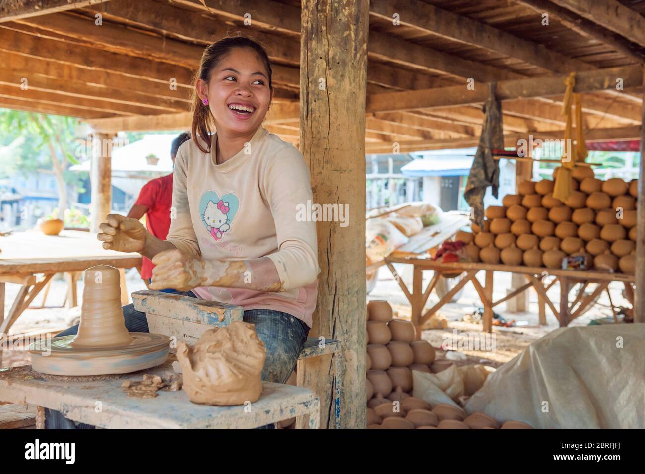 Une femme souriante faisant un pot d'argile sur une roue de poterie. Province de Kampong Chhnang, Cambodge, Asie du Sud-est Banque D'Images