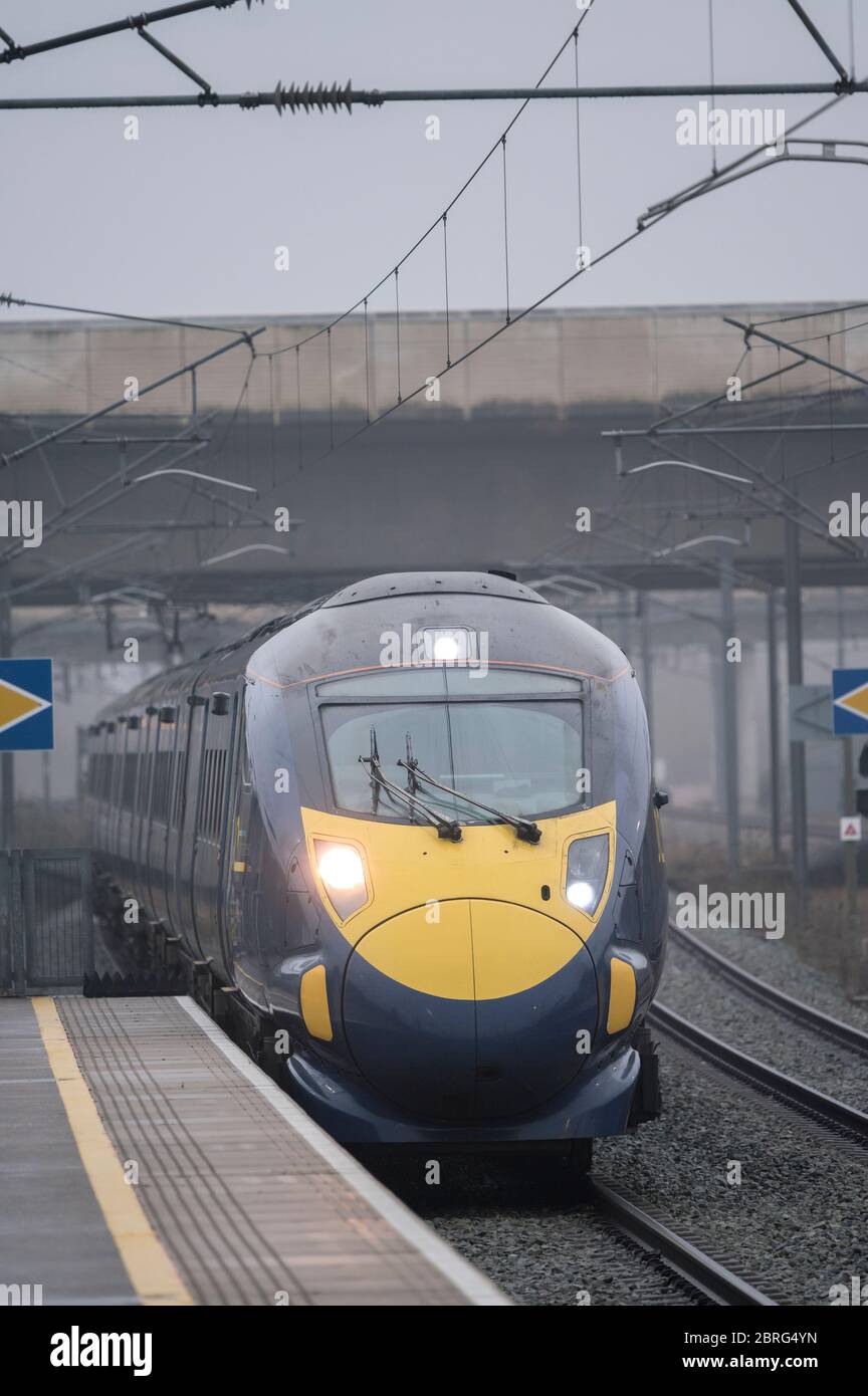 Train de voyageurs à grande vitesse de classe 395 dans la décoration du sud-est arrivant à une gare ferroviaire par une journée de brouillard en Angleterre. Banque D'Images