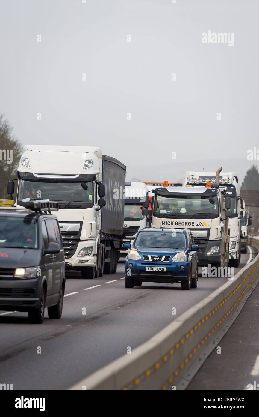 Circulation passant par des travaux routiers sur une autoroute très fréquentée en Angleterre, au Royaume-Uni. Banque D'Images