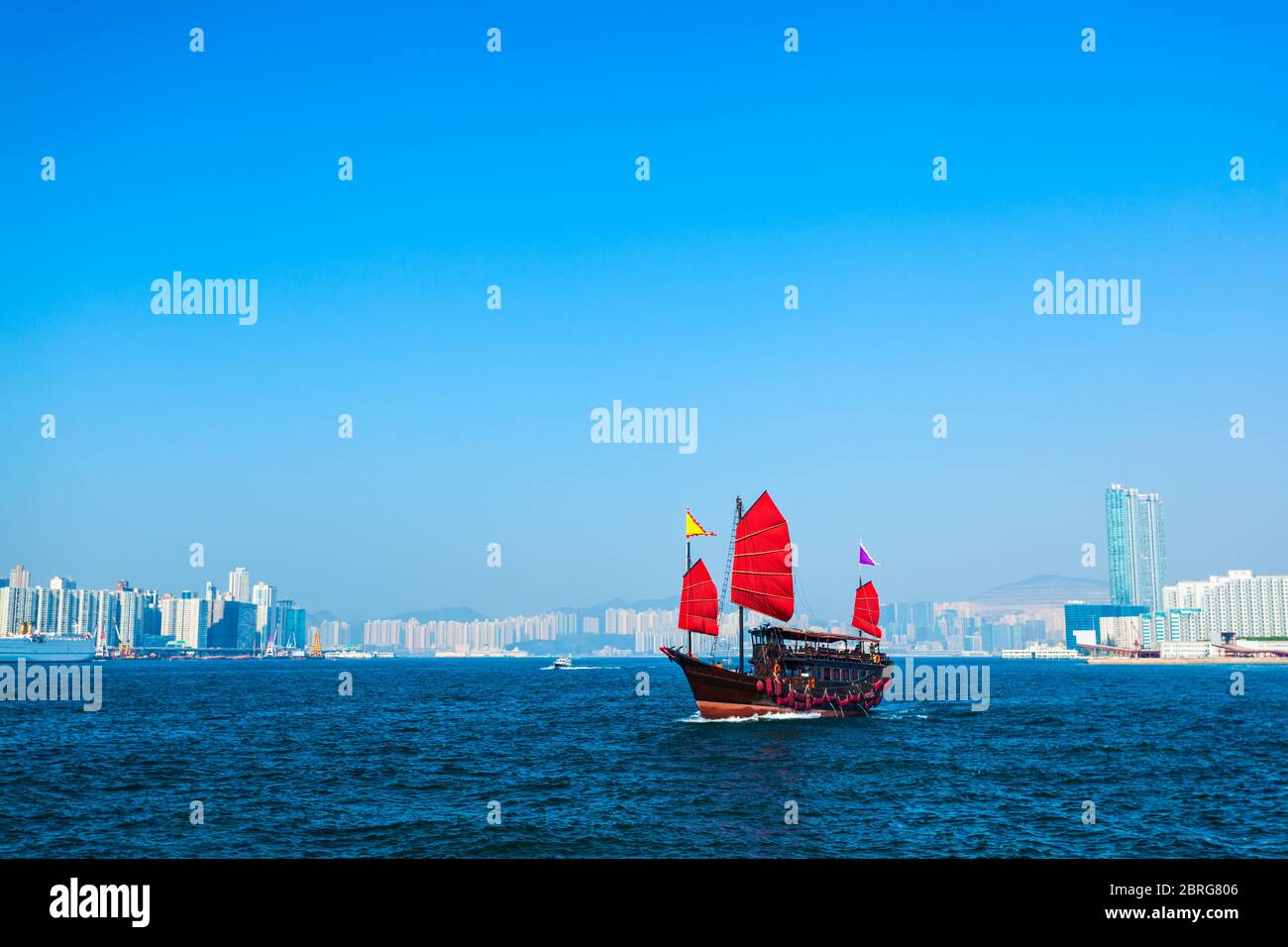 Croisière touristique de style traditionnel avec voiles rouges traverse le port de Victoria de Kowloon à l'île de Hong Kong Banque D'Images