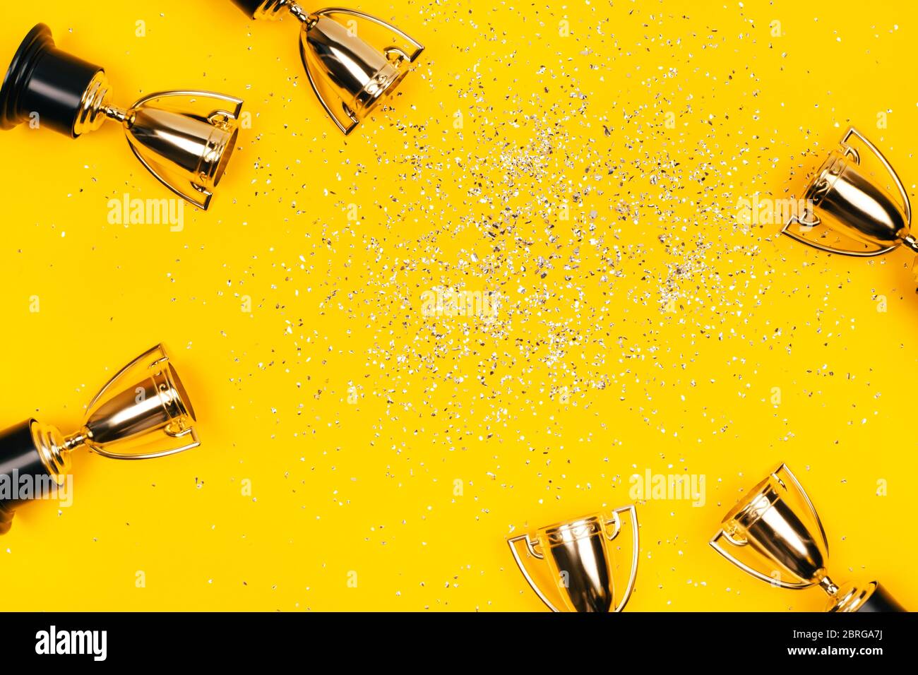Coupes Golden Winner avec des taches d'argent sur un fond jaune avec espace de copie. Concept festif. Style plat. Banque D'Images