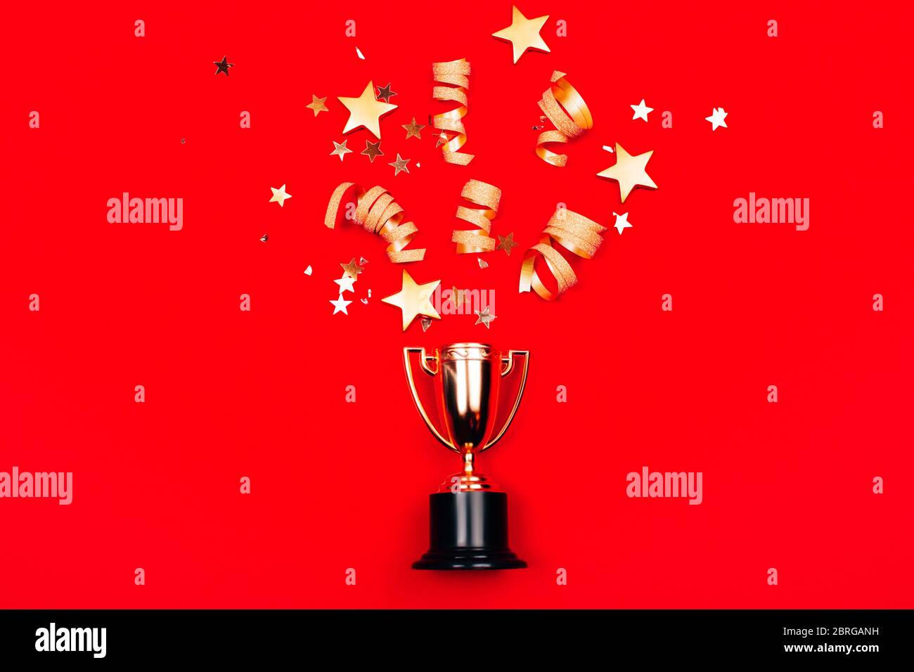 Coupe Golden Winners avec confetti sur fond rouge. Style de pose à plat. Concept de champion. Banque D'Images
