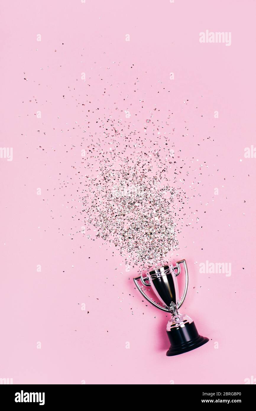 Une tasse gagnante en argent aux couleurs vives sur fond pastel. Style lat Lay. Banque D'Images