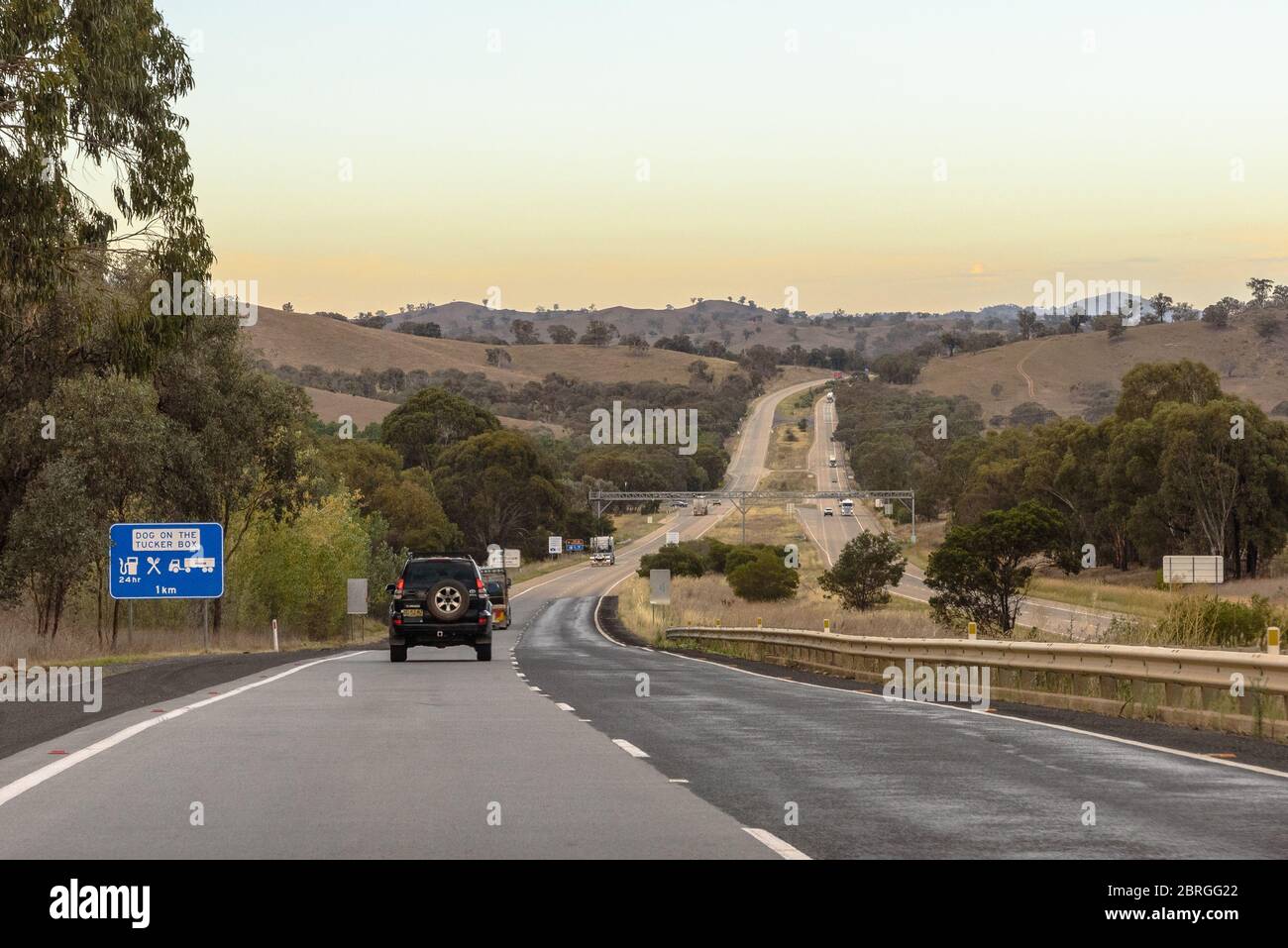 Voitures sur l'autoroute M31 au nord de Gundagai en approchant le chien sur une sortie Tucker Box Banque D'Images