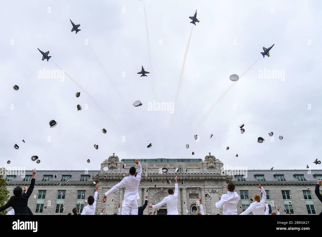 Annapolis, États-Unis d'Amérique. 20 mai 2020. Annapolis, États-Unis d'Amérique. 20 mai 2020. L'escadron de démonstration de vol de la marine américaine, les Blue Angels, survole Bancroft Hall tandis que les midshipmen lancent leur chapeau pour conclure la cinquième épreuve de prestation de serment pour la classe de l'Académie navale de 2020 en vertu de la COVID-19, règlement de distance sociale pandémique du coronavirus le 20 mai 2020 à Annapolis, Maryland. Environ 1,000 midshipmen seront diplômés et assermentés au cours de cinq événements et d'une cérémonie virtuelle. Crédit : Dana Legg/DOD photo/Alay Live News Banque D'Images