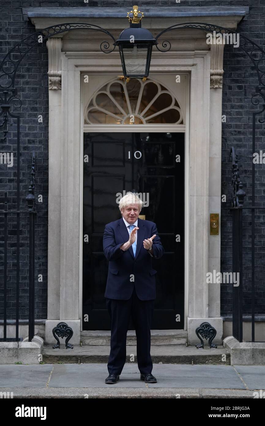 Le Premier ministre Boris Johnson se tient à Downing Street, Londres, pour se joindre aux applaudissements pour saluer les héros locaux lors du Clap national de jeudi pour que les soignants reconnaissent et soutiennent les travailleurs du NHS et les soignants qui luttent contre la pandémie du coronavirus. Banque D'Images