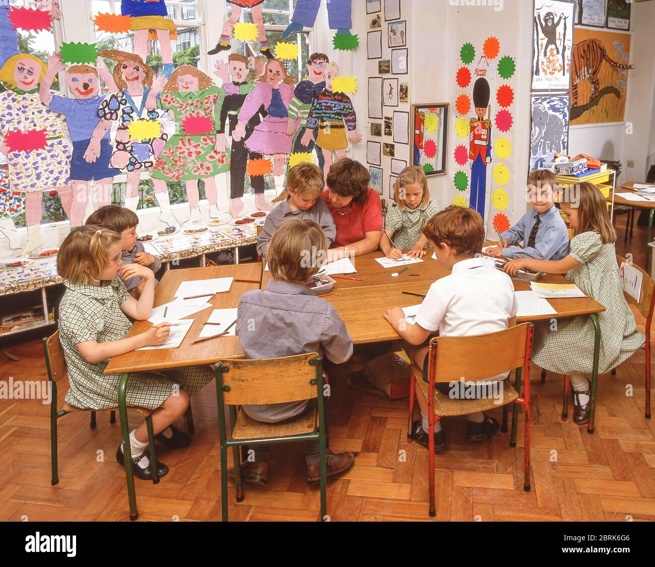 Enseignant aidant les élèves de l'école primaire en classe d'art, Surrey, Angleterre, Royaume-Uni Banque D'Images