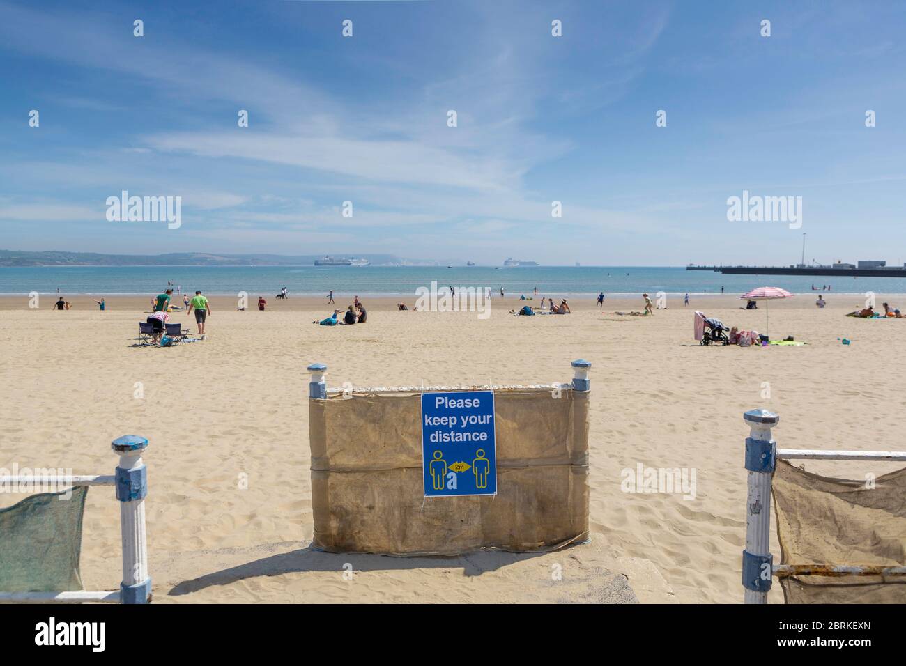 Il y a beaucoup de place sur les sables dorés de Weymouth Beach à Dorset aujourd'hui, alors que la demi-session de l'école de la semaine prochaine approche rapidement. Panneaux autour de la promenade RE Banque D'Images