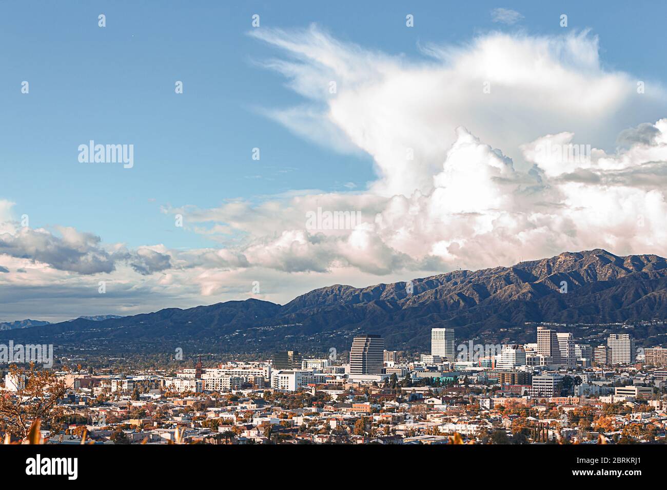 vue panoramique sur les entreprises et les maisons de la ville avec des maisons à flanc de colline et des montagnes cumulous et nimbus nuages Banque D'Images