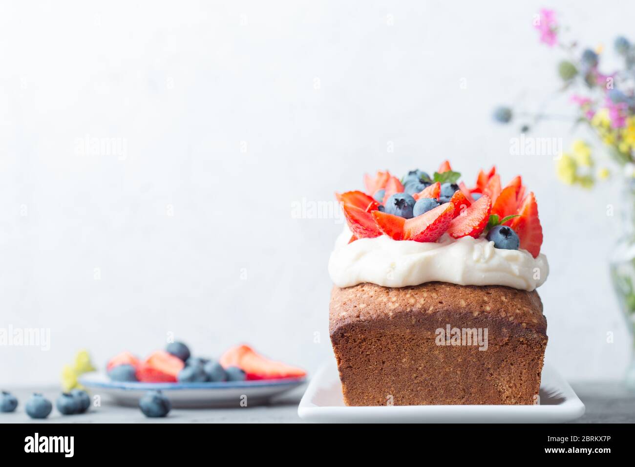 Dessert d'été, gâteau aux baies maison avec glaçage au fromage à la crème, fraises fraîches et bleuets, gros plan Banque D'Images