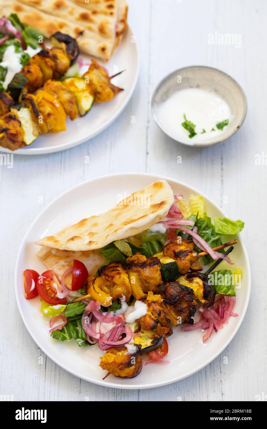Brochettes tandoori de poulet et de courgette épicées avec salade et pain plat Banque D'Images