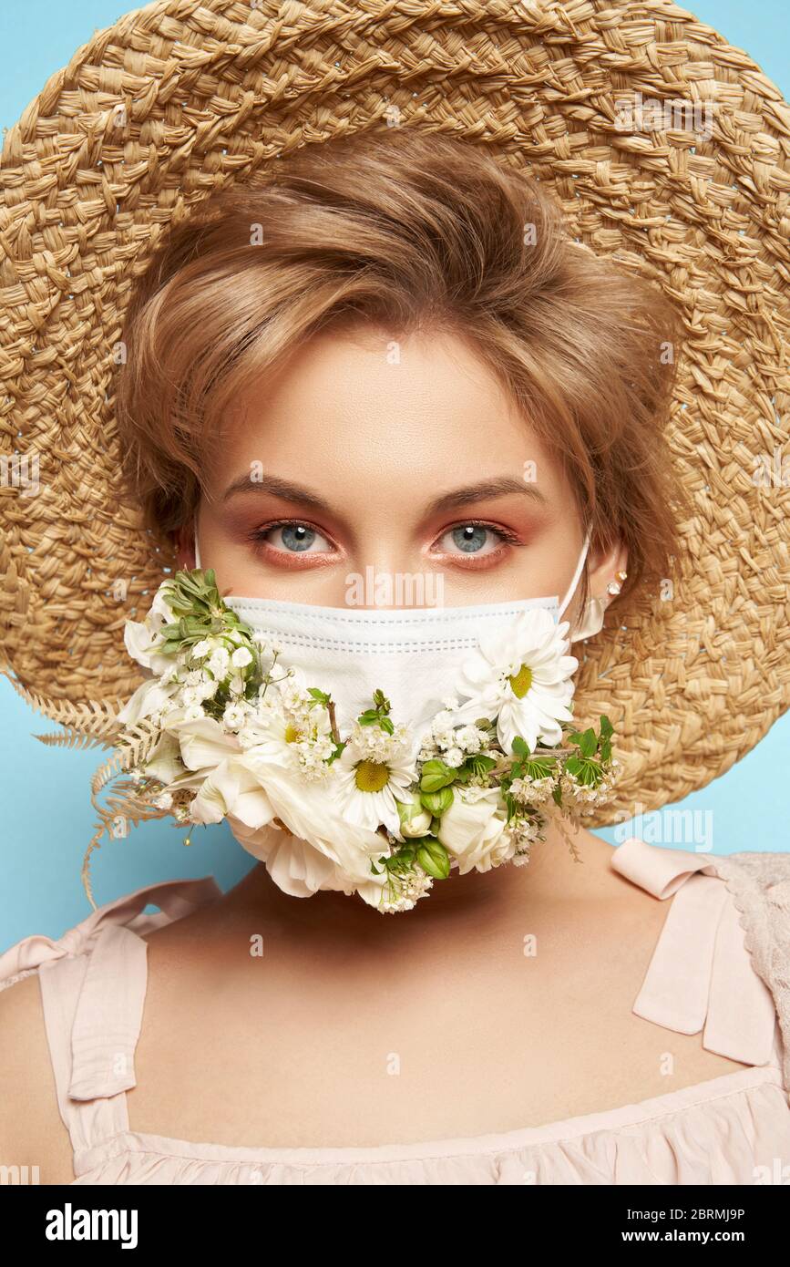 Motif masque avec fleurs. Portrait de la belle femme avec les yeux bleus,  chapeau de paille et masque Photo Stock - Alamy