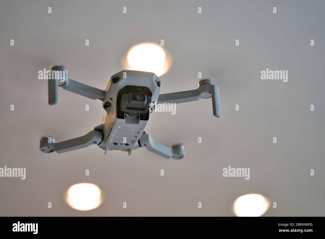 Drone volant à l'intérieur avec plafond visible en arrière-plan. Dessous de drone en vol à l'intérieur de la maison. Banque D'Images