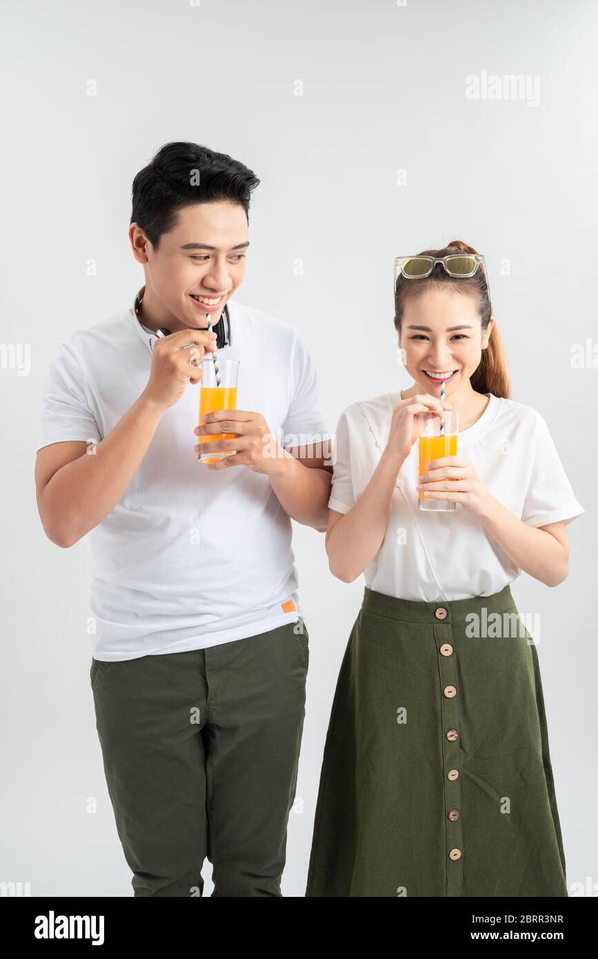 l'amour, la famille, la nourriture saine et le concept de bonheur - sourire heureux couple boire du jus sur fond blanc Banque D'Images