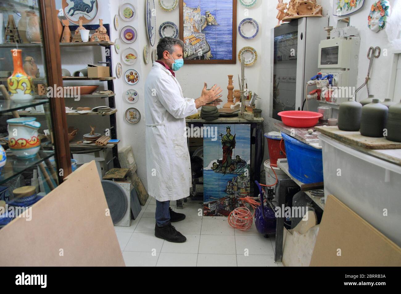 Un céramiste à l'intérieur de son atelier travaille l'argile pour la préparation d'articles à vendre aux touristes étrangers et italiens . Une tradition ancienne typique Banque D'Images