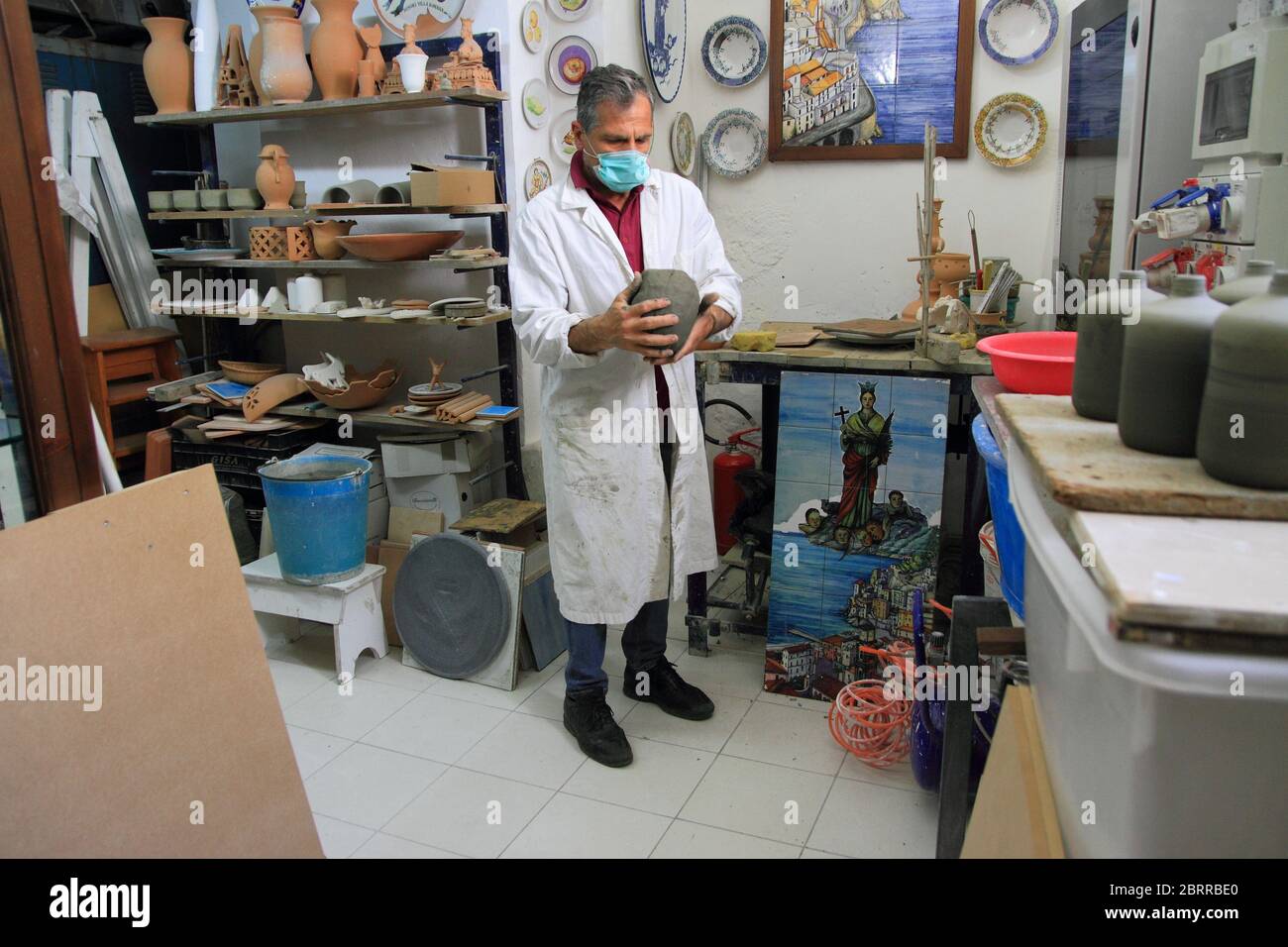 Un céramiste à l'intérieur de son atelier travaille l'argile pour la préparation d'articles à vendre aux touristes étrangers et italiens . Une tradition ancienne typique Banque D'Images