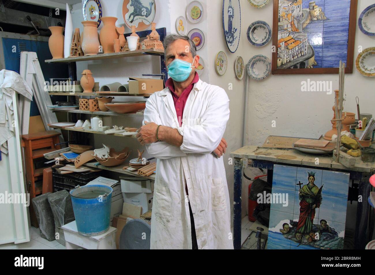 Un céramiste dans son atelier pose parmi les articles à vendre aux touristes étrangers et italiens . Une tradition typique de la côte amalfitaine . Banque D'Images