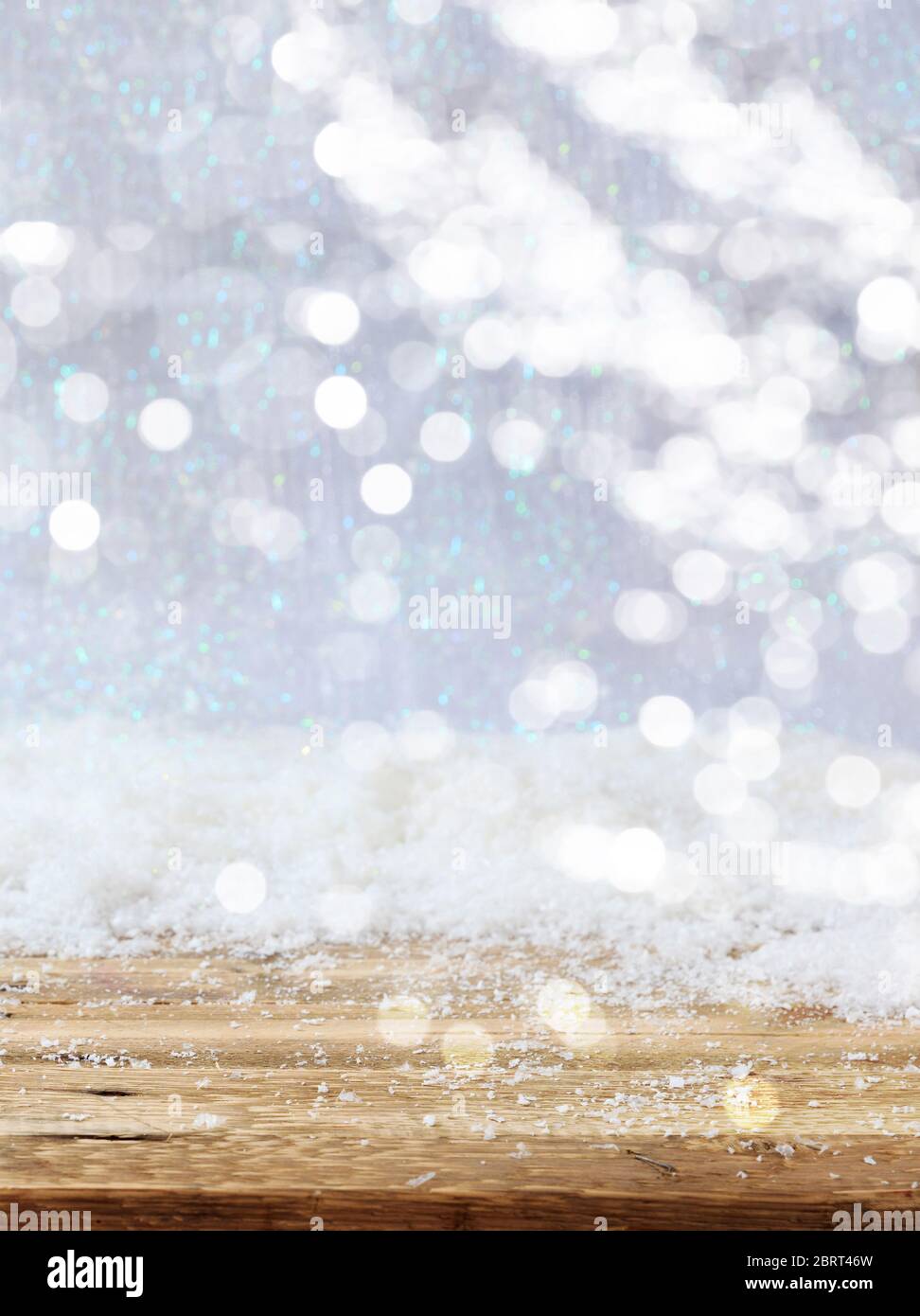 Fond de bokeh enneigé de Noël. Chute de neige sur une table en bois, maquette de carte de vœux de Noël, modèle, vertical, espace de copie Banque D'Images