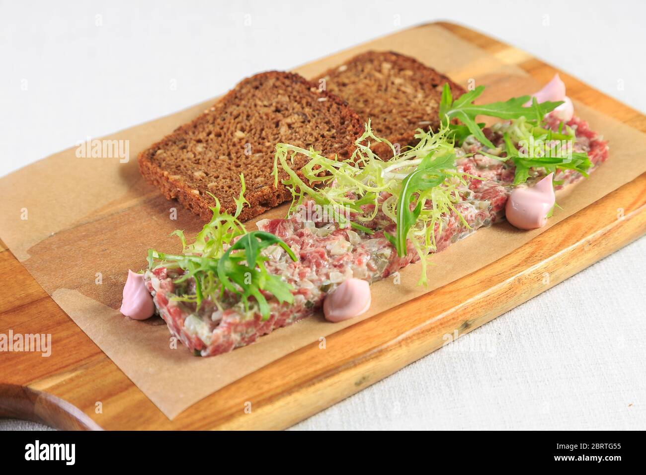 Tartare de boeuf avec jaune d'œuf sur une table en bois Banque D'Images