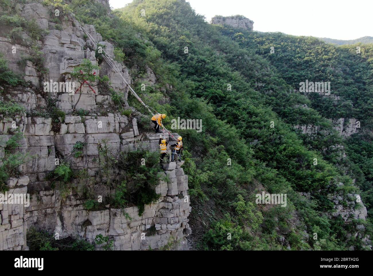 Pékin, Chine. 21 mai 2020. Dans cette photo aérienne prise le 21 mai 2020, les membres du personnel de la section Yueshan de China Railway Zhengzhou Group Co., Ltd. Travaillent sur la falaise de Taihang Mountain dans la province de Henan, au centre de la Chine. Pour assurer la sécurité des trains qui passent, les travailleurs doivent inspecter les montagnes et retirer les roches dangereuses. Credit: Hao Yuan/Xinhua/Alay Live News Banque D'Images
