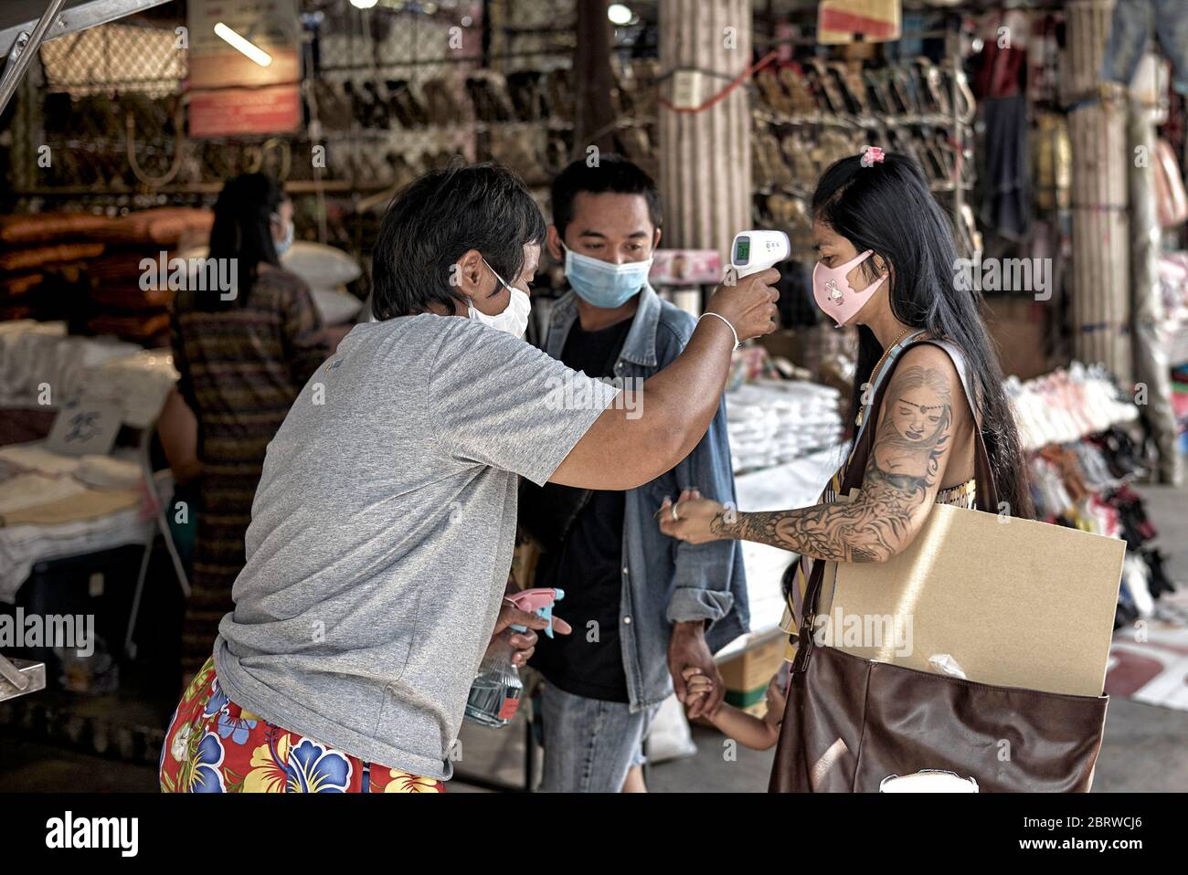 Vérifiez la température Covid-19 avec un thermomètre sans contact et désinfectez les mains des clients avant de pénétrer le marché de magasinage. Thaïlande Asie du Sud-est Banque D'Images