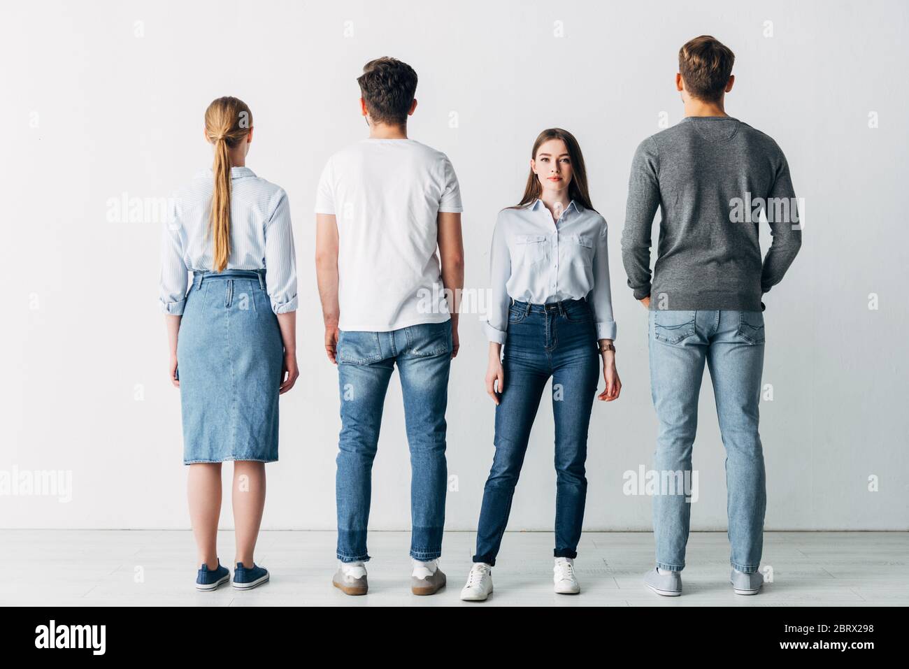 Belle fille regardant l'appareil photo près des employés dans le bureau Banque D'Images